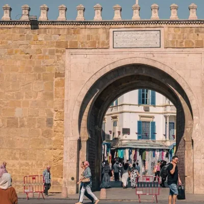 Explore the iconic Bab El Bhar city gate in Tunis, showcasing historical architecture and vibrant street life.